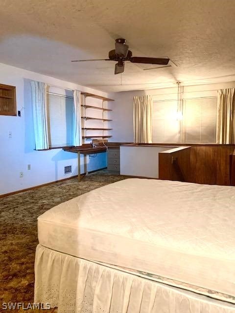 unfurnished bedroom with dark carpet and ceiling fan