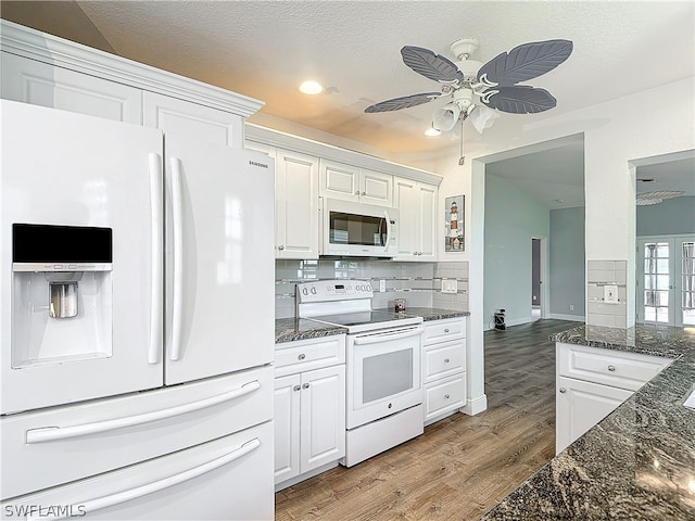 kitchen featuring white appliances, backsplash, ceiling fan, white cabinets, and light hardwood / wood-style floors