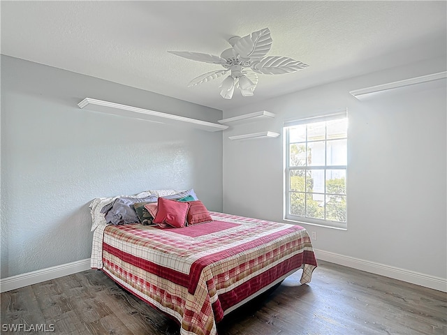 bedroom featuring a textured ceiling, ceiling fan, and dark hardwood / wood-style floors