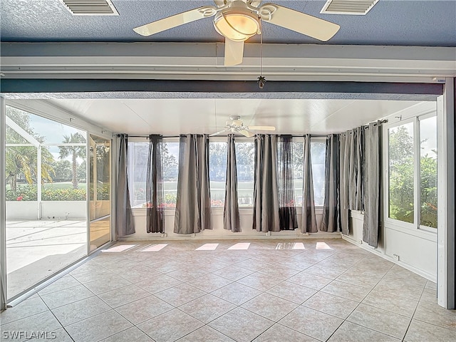 tiled spare room with a textured ceiling and ceiling fan