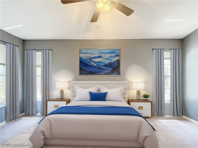 carpeted bedroom featuring a textured ceiling and ceiling fan