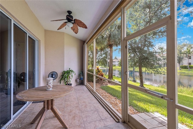 sunroom with a water view, vaulted ceiling, ceiling fan, and a healthy amount of sunlight