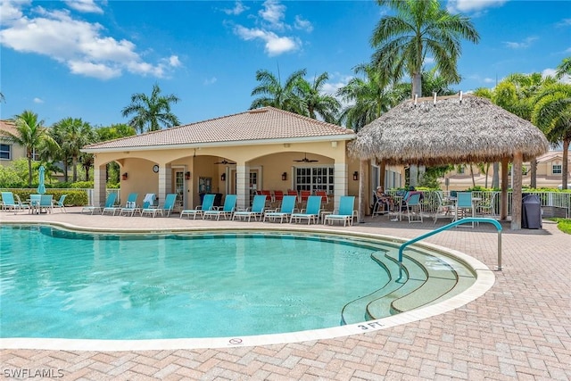 view of swimming pool featuring ceiling fan and a patio