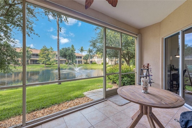 unfurnished sunroom with ceiling fan, plenty of natural light, and a water view