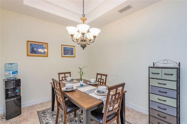 dining room featuring a raised ceiling, light tile patterned flooring, and an inviting chandelier