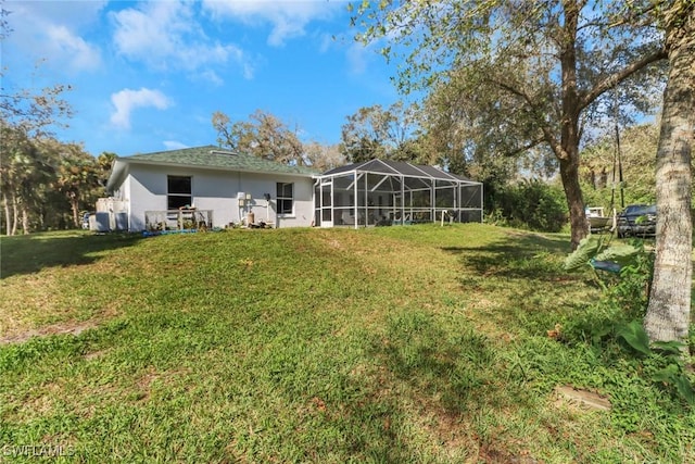 back of house with a lanai and a yard