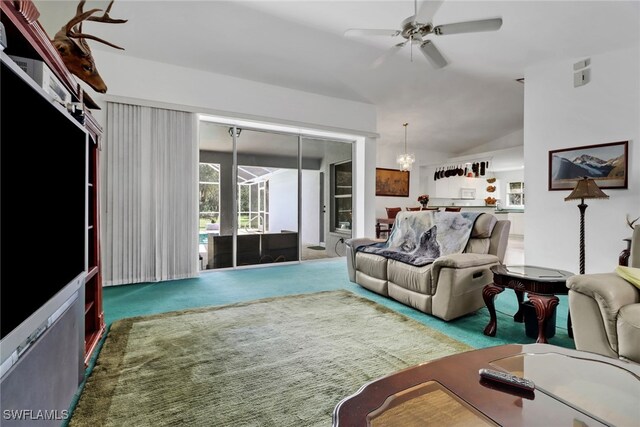 living room with carpet flooring, ceiling fan with notable chandelier, and vaulted ceiling