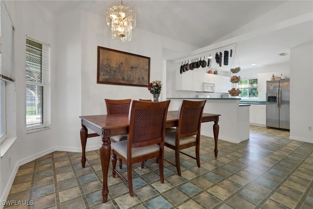 dining room with lofted ceiling and an inviting chandelier