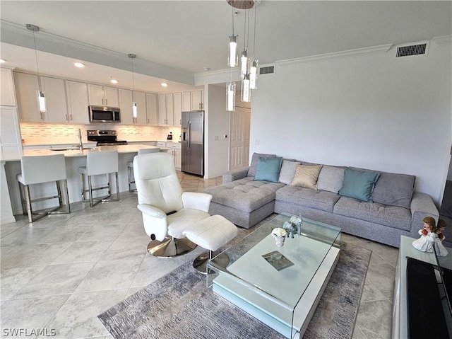 tiled living room featuring sink and ornamental molding