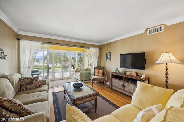 living area featuring visible vents, crown molding, and wood finished floors