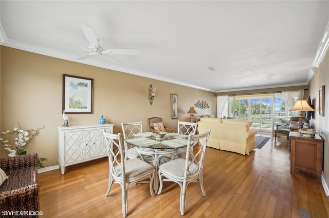 dining area featuring ornamental molding, baseboards, and light wood finished floors