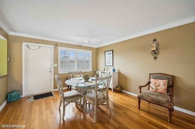 dining space featuring light wood finished floors, ceiling fan, baseboards, and crown molding