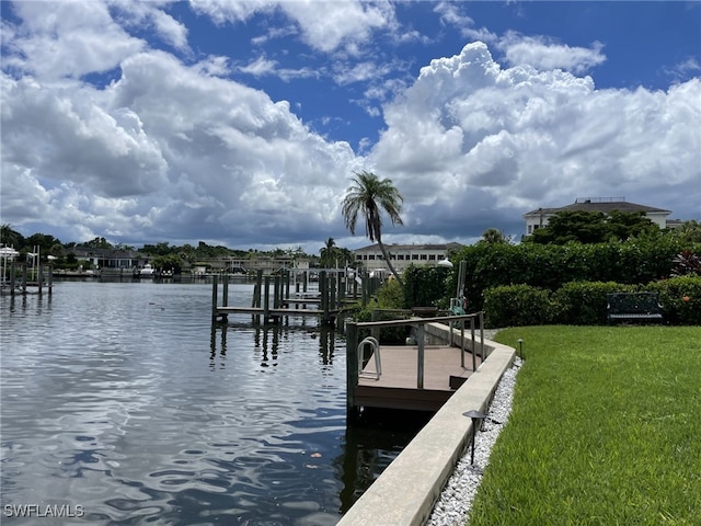 dock area with a water view and a lawn