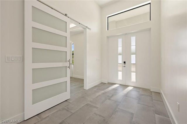 entrance foyer featuring plenty of natural light, a barn door, and french doors