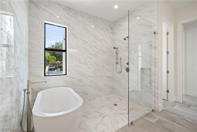 bathroom with tile walls and shower with separate bathtub