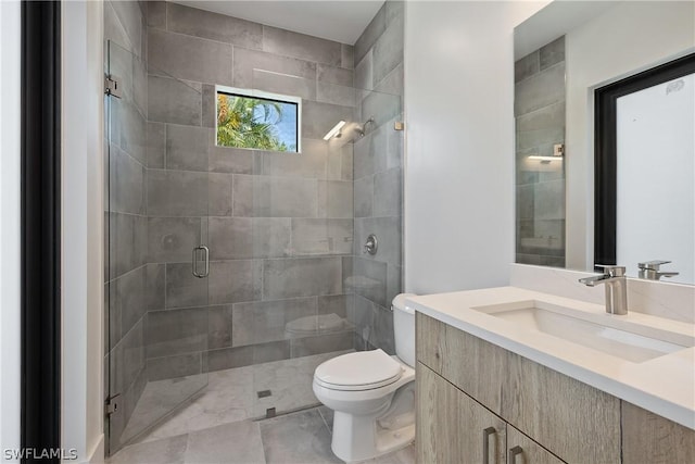 bathroom with vanity, toilet, and a shower with shower door