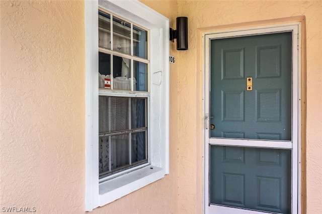 entrance to property featuring stucco siding