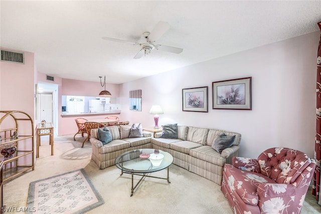 carpeted living room featuring ceiling fan