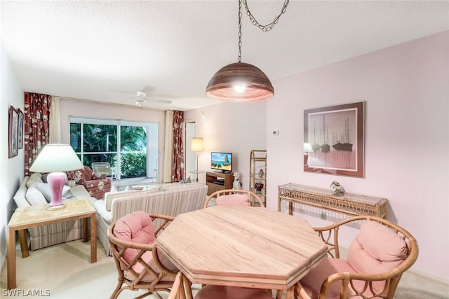 carpeted dining area with ceiling fan