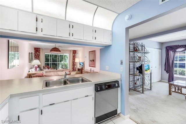 kitchen featuring white cabinets, light colored carpet, a sink, light countertops, and stainless steel dishwasher
