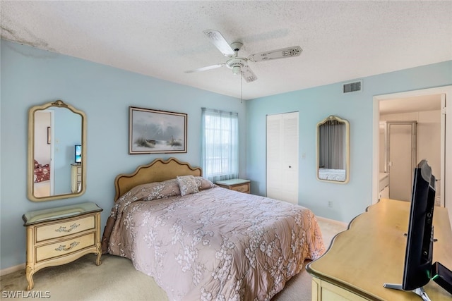 bedroom with a textured ceiling, visible vents, light carpet, and a closet