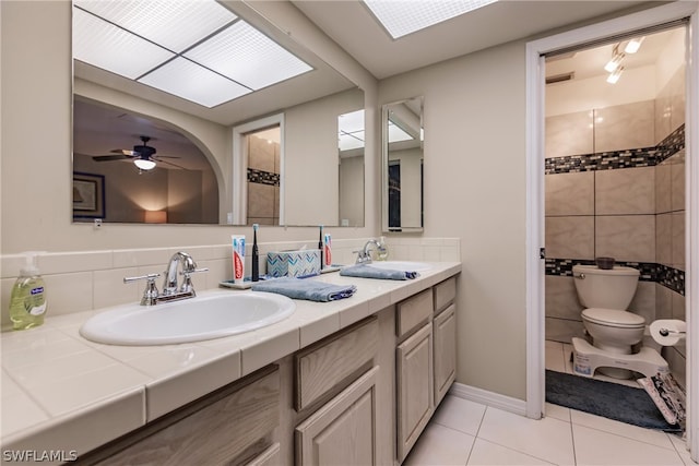 bathroom with toilet, vanity, tile patterned floors, and ceiling fan