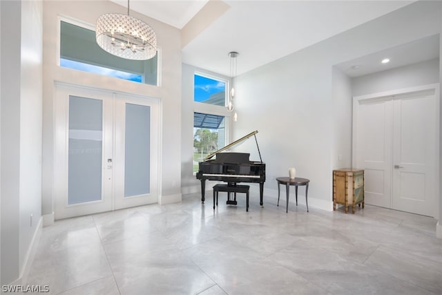 foyer entrance featuring french doors, a towering ceiling, and an inviting chandelier