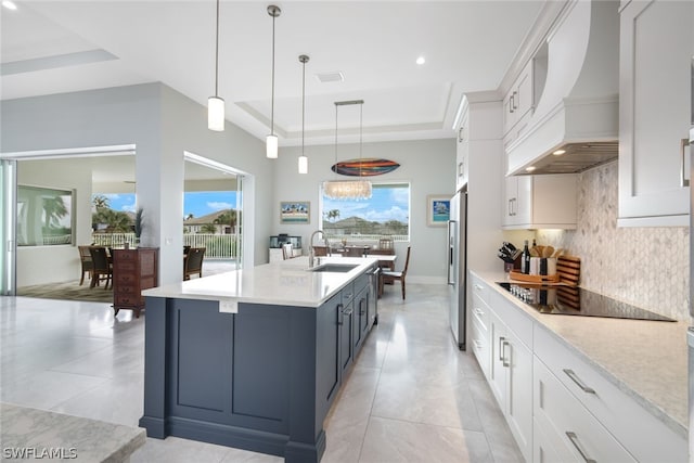 kitchen featuring white cabinets, custom range hood, and a raised ceiling