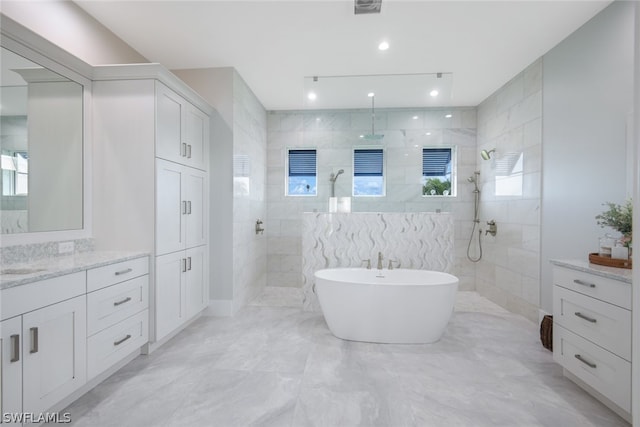 bathroom featuring vanity, plus walk in shower, and tile walls