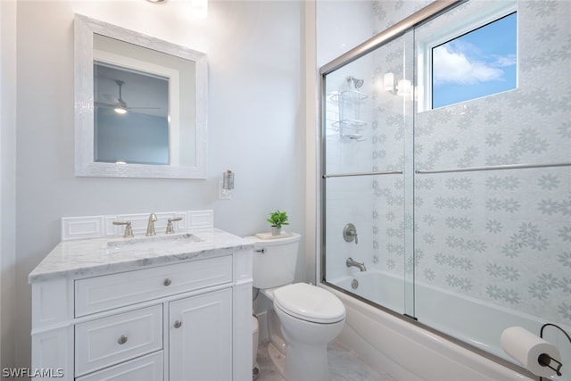 full bathroom with ceiling fan, vanity, bath / shower combo with glass door, and toilet