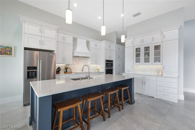 kitchen featuring white cabinets, sink, custom range hood, and stainless steel appliances