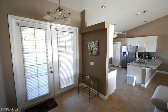 doorway to outside with tile patterned flooring and lofted ceiling