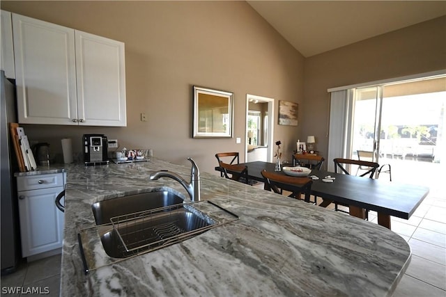 kitchen with white cabinetry, sink, and light stone counters