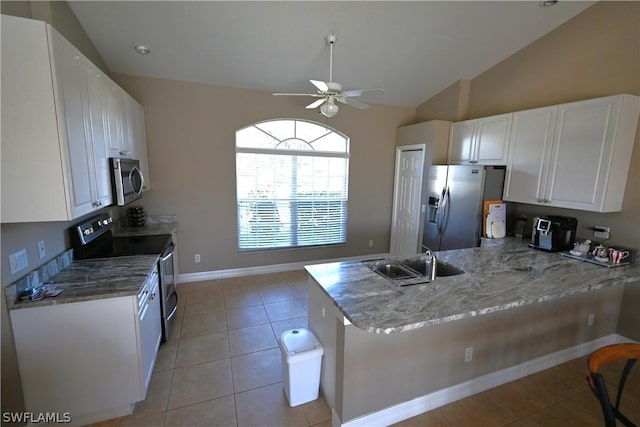 kitchen featuring vaulted ceiling, appliances with stainless steel finishes, white cabinetry, sink, and kitchen peninsula