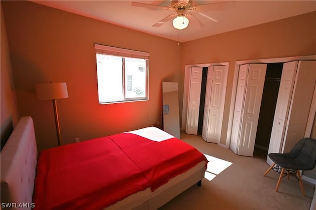 carpeted bedroom with multiple closets and ceiling fan