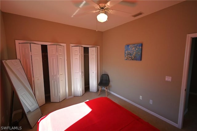 unfurnished bedroom with multiple closets and ceiling fan