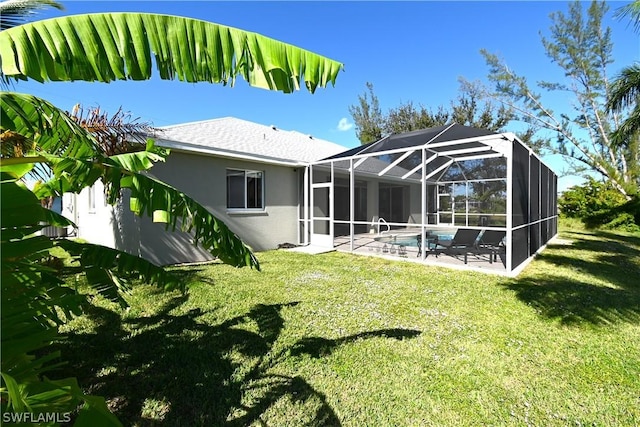 rear view of house with a yard, a patio area, and glass enclosure