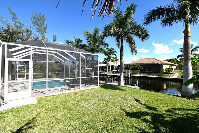 exterior space with a yard, a water view, and glass enclosure