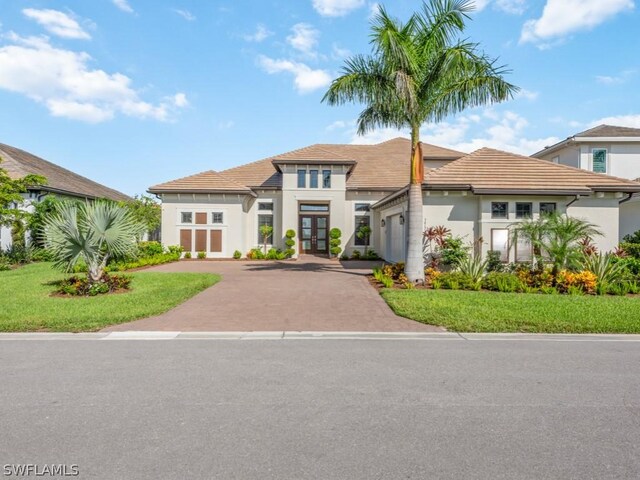 view of front of home with a garage, a front yard, and french doors