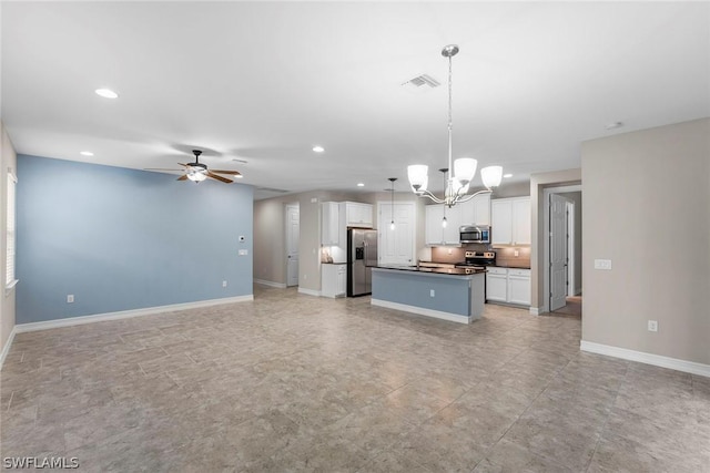 kitchen with appliances with stainless steel finishes, ceiling fan with notable chandelier, decorative light fixtures, white cabinetry, and a center island