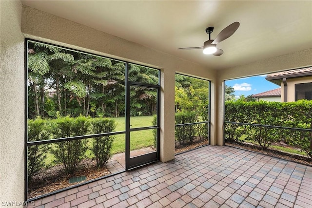 unfurnished sunroom with ceiling fan