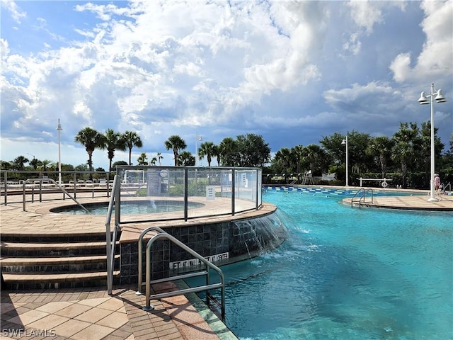 view of swimming pool with pool water feature and a patio area