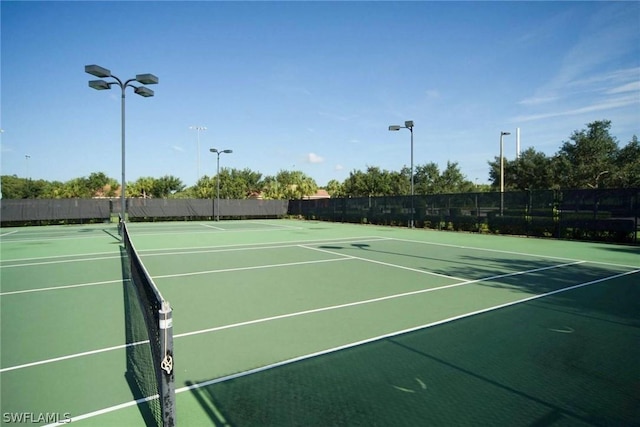 view of tennis court with basketball hoop