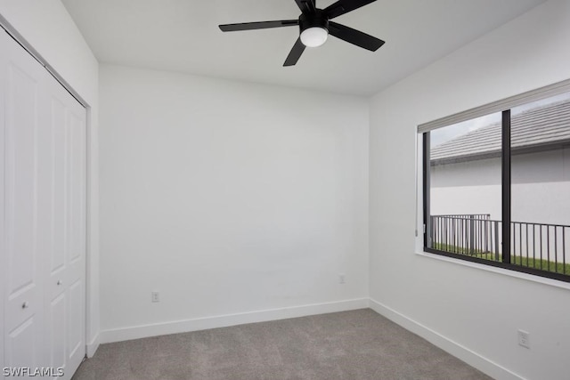 carpeted spare room with a wealth of natural light and ceiling fan