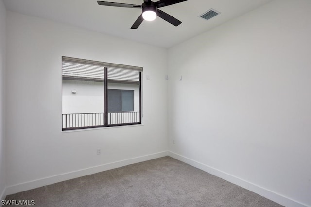 carpeted spare room featuring ceiling fan