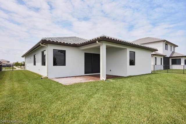 rear view of house featuring a patio area and a yard