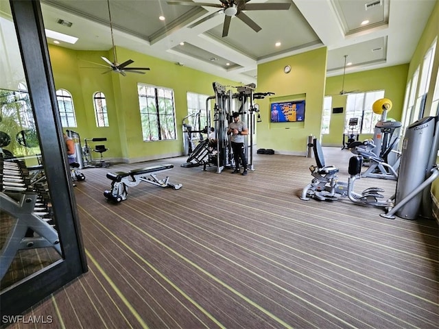 exercise room featuring carpet flooring, ceiling fan, crown molding, and coffered ceiling