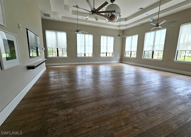 spare room featuring a tray ceiling, ceiling fan, and dark hardwood / wood-style flooring