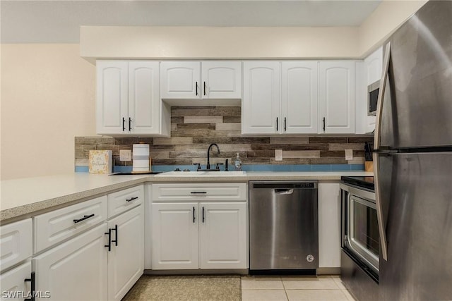 kitchen featuring sink, stainless steel appliances, white cabinets, decorative backsplash, and light tile patterned flooring