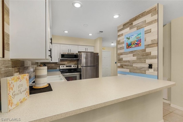 kitchen with white cabinetry, backsplash, kitchen peninsula, light tile patterned floors, and appliances with stainless steel finishes